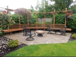 Hardscaping Brick patio hardscaping with two tables and chairs and a wooden frame